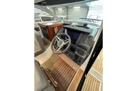 Interior of 2023 Nimbus 305 Coupe, featuring modern helm and wooden flooring.