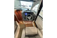 Interior view of 2023 Nimbus 305 Coupe boat cockpit with steering wheel and controls.