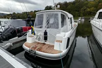 2023 Nimbus 305 Coupe docked at marina, rear view with Swedish flag.