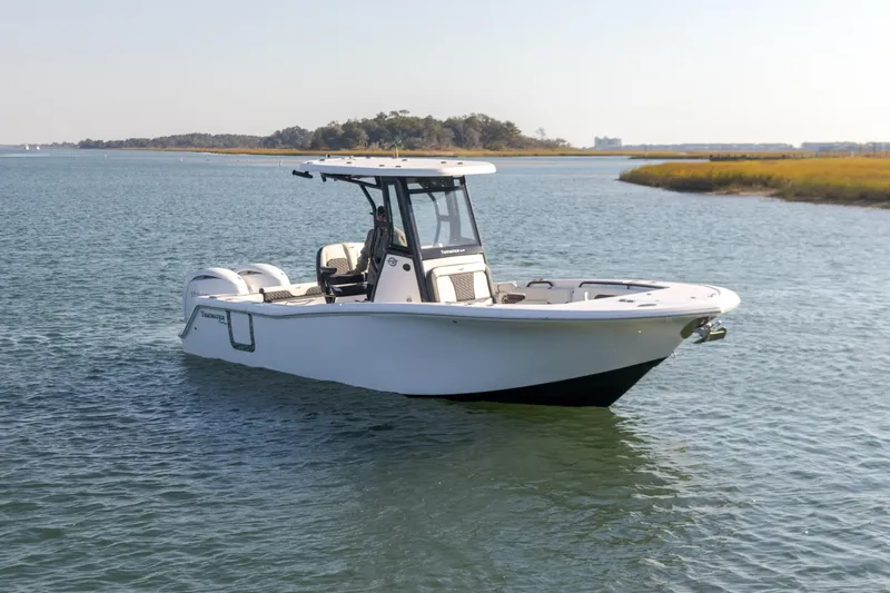  Yacht Photos Pics 2024 Tidewater 256 CC Adventure boat on calm water, scenic background.