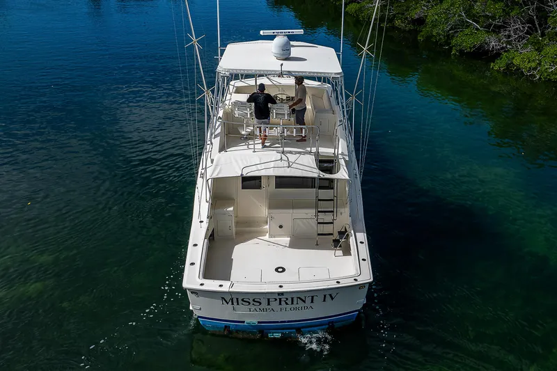 Miss Print IV Yacht Photos Pics 1987 Hatteras 52 Convertible boat cruising in clear waters.