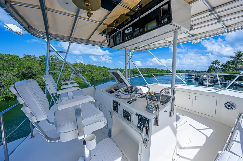 Miss Print IV Yacht Photos Pics 1987 Hatteras 52 Convertible yacht helm station with white seating and control panel.