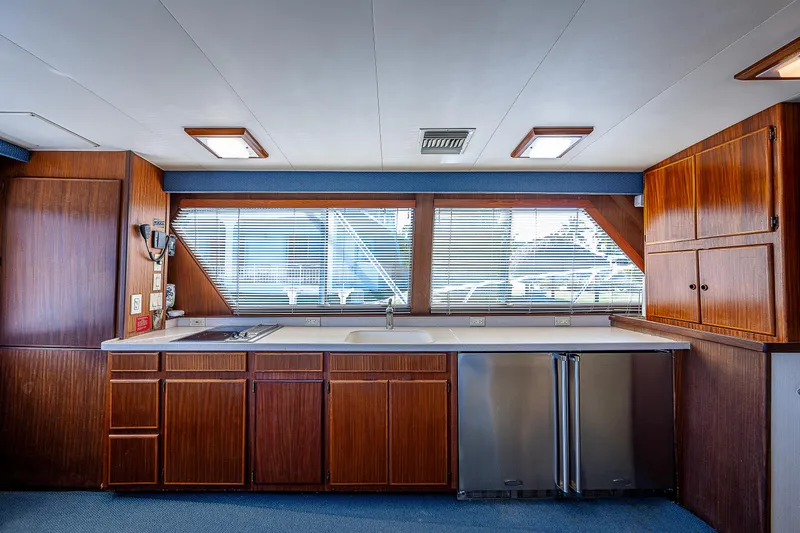 Miss Print IV Yacht Photos Pics 1987 Hatteras 52 Convertible yacht kitchen with wooden cabinets and stainless steel appliances.