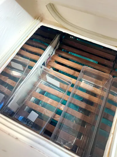 Della Therese Yacht Photos Pics Wooden slatted storage area with clear plastic containers on a 1986 Tayana Vancouver 42.