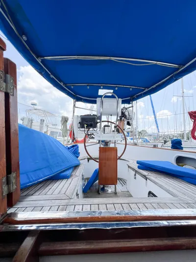 Della Therese Yacht Photos Pics 1986 Tayana Vancouver 42 sailboat cockpit with blue canopy and seating, docked at marina.