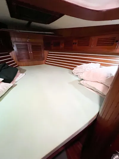 Della Therese Yacht Photos Pics Cozy cabin interior of 1986 Tayana Vancouver 42 sailboat with wooden paneling and bedding.