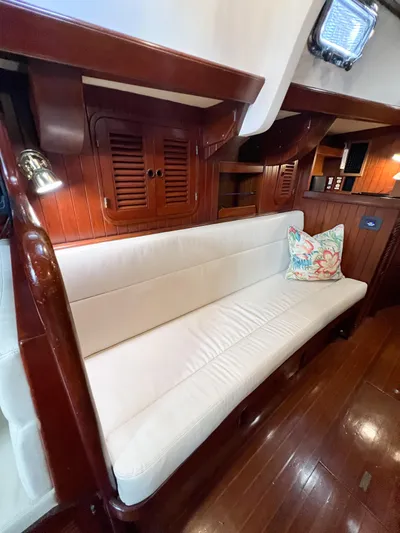 Della Therese Yacht Photos Pics Interior of 1986 Tayana Vancouver 42 yacht with white cushioned seating and wooden paneling.