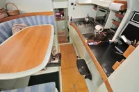 Interior of 2008 Trimaran POLYNESIA 42, featuring a compact kitchen and dining area.