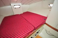 Cozy cabin interior of 2008 Trimaran POLYNESIA 42 with striped bedding.