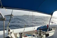 2008 Trimaran POLYNESIA 42 sailing on open sea with distant islands in view.