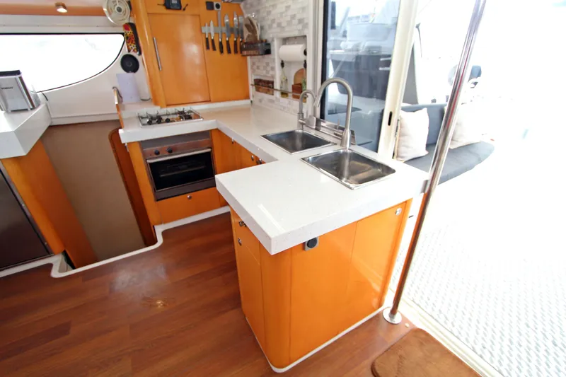  Yacht Photos Pics Modern kitchen interior of 2008 Fountaine Pajot Orana 44 catamaran with orange cabinetry.