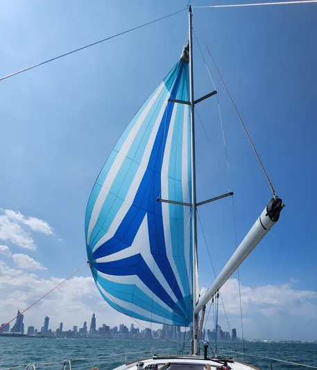 Superstition Yacht Photos Pics Beneteau Oceanis 40 sailing with colorful spinnaker against city skyline, 2012 model.