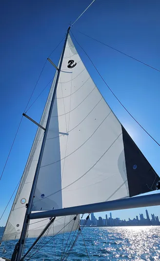 Superstition Yacht Photos Pics Beneteau Oceanis 40 sailboat on sunny day, city skyline in background.