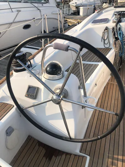 Superstition Yacht Photos Pics Steering wheel of a 2012 Beneteau Oceanis 40 sailboat on a wooden deck.