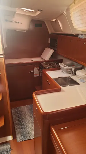 Superstition Yacht Photos Pics Interior of 2012 Beneteau Oceanis 40 yacht, featuring a compact kitchen with wooden cabinetry.