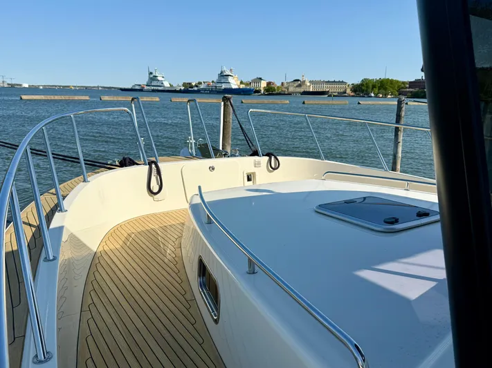  Yacht Photos Pics 2016 Targa 44 yacht deck with wooden flooring, overlooking a calm harbor.