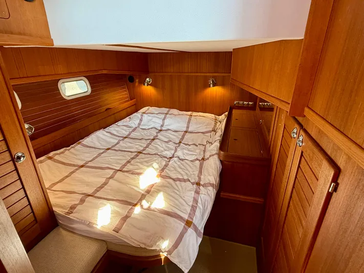  Yacht Photos Pics Cozy cabin interior of 2016 Targa 44 boat with wooden paneling and bed.