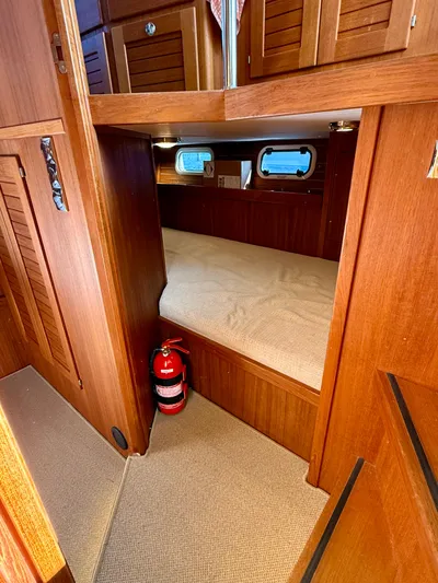  Yacht Photos Pics Cozy cabin interior of 2016 Targa 44 boat with wooden finish and fire extinguisher.