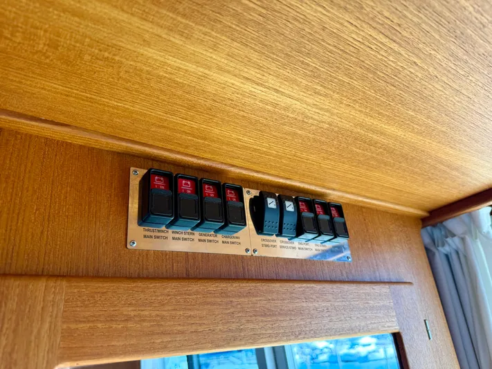 Yacht Photos Pics Control panel with switches on a 2016 Targa 44 boat, mounted on a wooden surface.