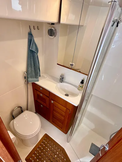  Yacht Photos Pics Compact bathroom in a 2016 Targa 44 boat with wooden cabinetry and modern fixtures.
