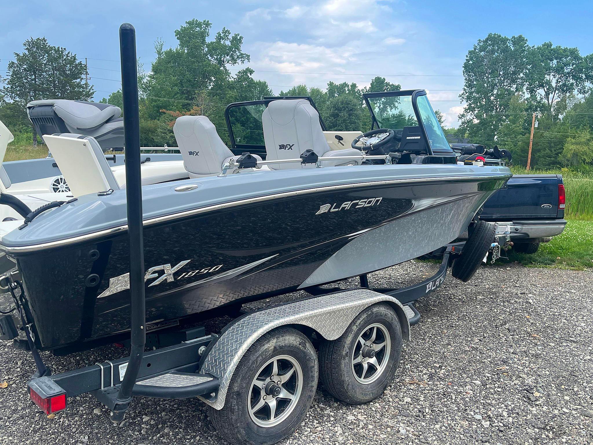 2018 Larson 1850 FX DC boat on trailer, parked outdoors.
