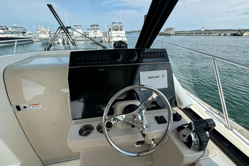  Yacht Photos Pics 2020 Boston Whaler 325 Conquest Pilothouse helm with steering wheel and controls, docked at marina.