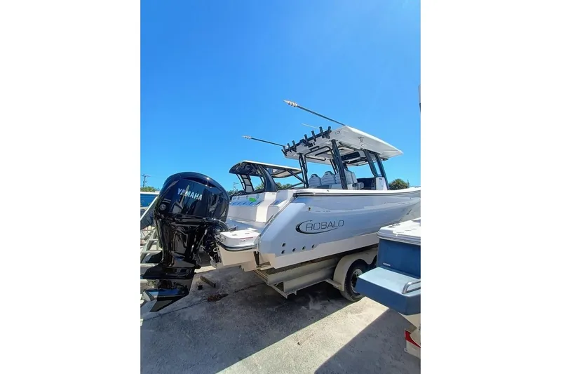300-115 Yacht Photos Pics 2025 Robalo 300 boat with Yamaha engine, parked on trailer under clear blue sky.