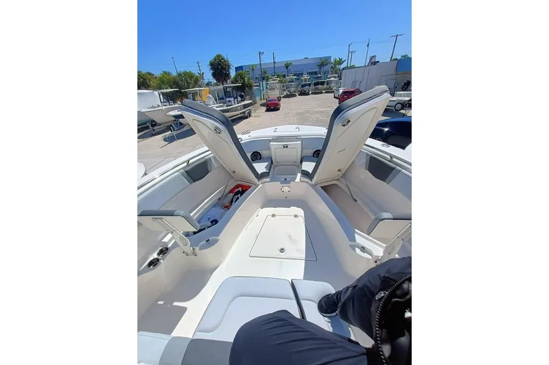 300-115 Yacht Photos Pics 2025 Robalo 300 boat interior with open storage compartments, docked outdoors.