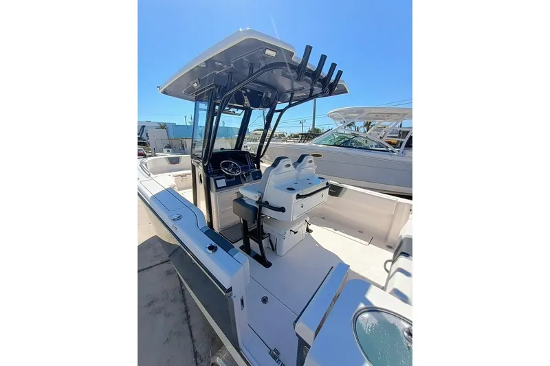 300-115 Yacht Photos Pics 2025 Robalo 300 boat interior with helm, seating, and rod holders under clear blue sky.