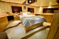 Luxurious 2007 Custom GULET yacht bedroom with elegant wood furnishings and cozy bedding.