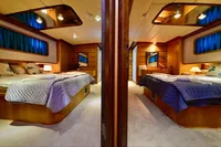Luxurious 2007 Custom GULET yacht cabin with twin beds, elegant decor, and ambient lighting.