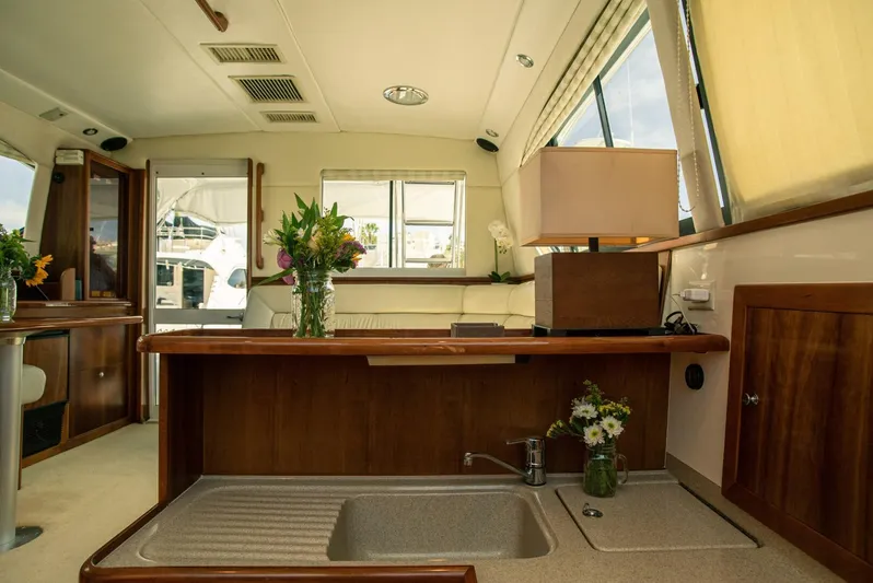 Skiesta Yacht Photos Pics Interior of 2002 Riviera 40 Flybridge yacht with modern kitchen and floral decor.