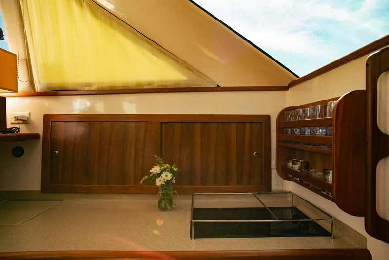 Skiesta Yacht Photos Pics Interior of 2002 Riviera 40 Flybridge yacht with wooden cabinets and glassware.
