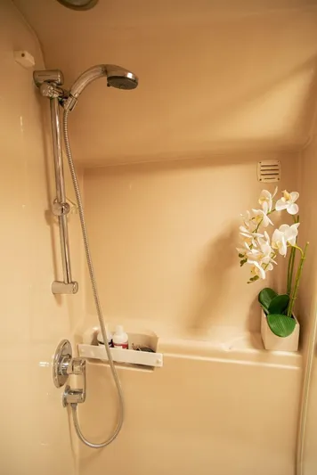 Skiesta Yacht Photos Pics Shower area in 2002 Riviera 40 Flybridge yacht with chrome fixtures and decorative orchid.