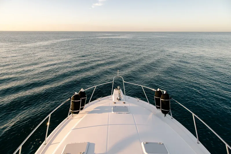 Skiesta Yacht Photos Pics Bow view of a 2002 Riviera 40 Flybridge yacht cruising on calm waters.