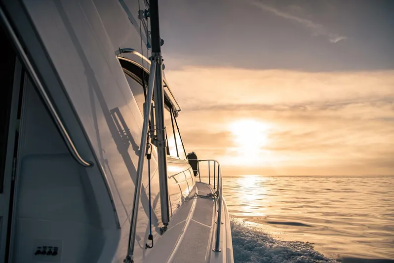 Skiesta Yacht Photos Pics Riviera 40 Flybridge 2002 yacht cruising at sunset on calm waters.