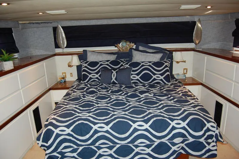  Yacht Photos Pics Luxurious bedroom in 1990 Hatteras 78 Aft Cockpit Motoryacht with nautical-themed bedding.