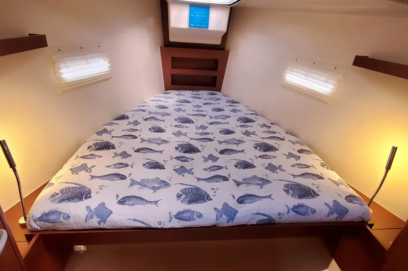  Yacht Photos Pics 2024 Hanse 388 yacht cabin with fish-patterned bedding and warm lighting.