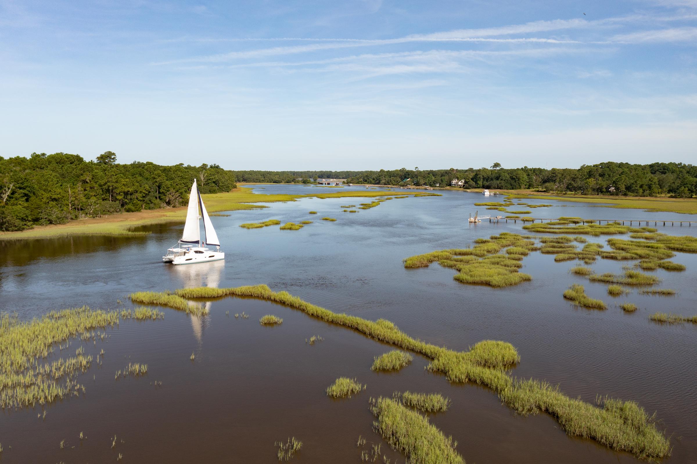 Sailboat cruising through serene marshland, Leopard 44 Owners Version, 2016 model.