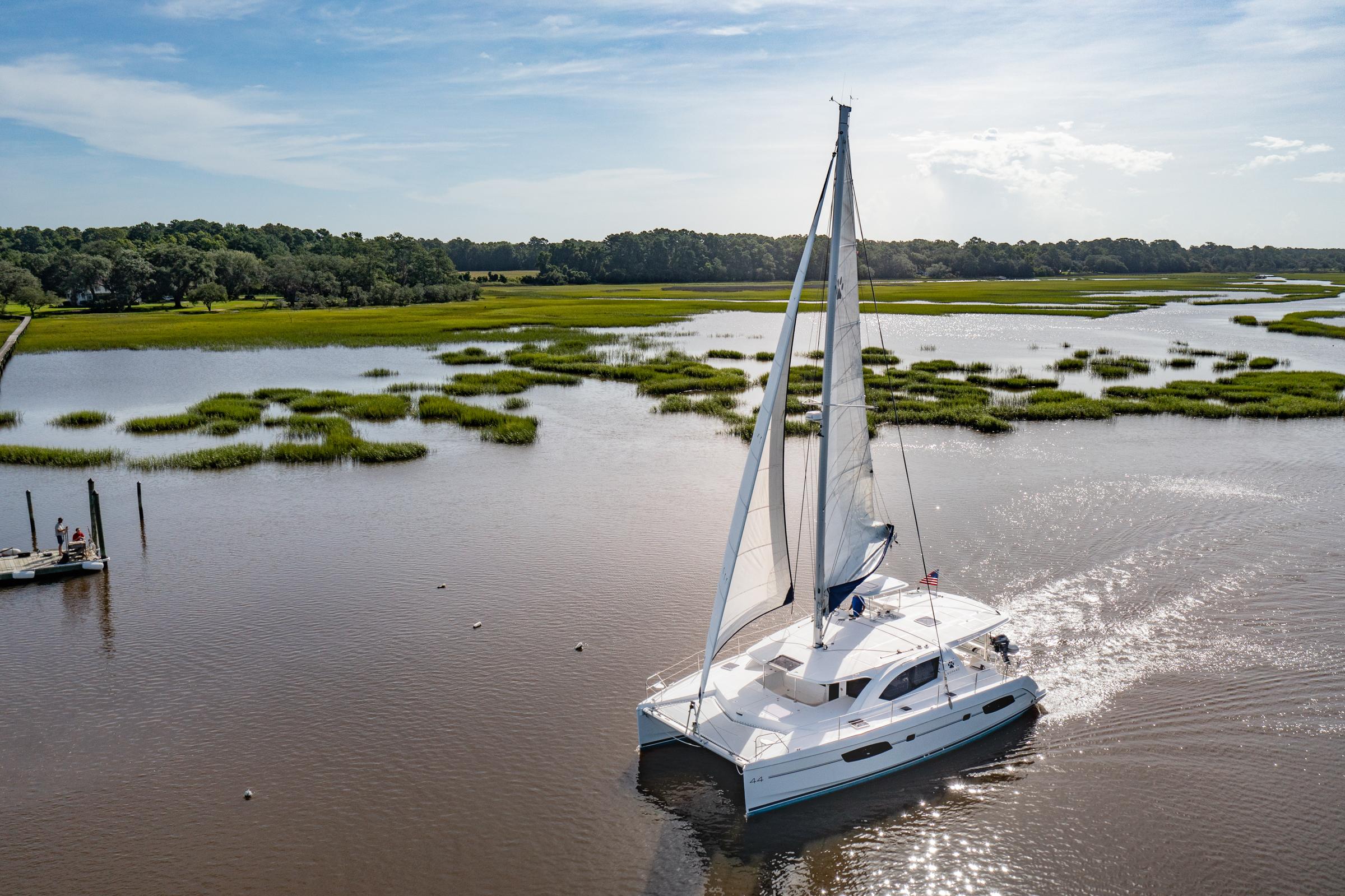 2016 Leopard 44 Owners Version catamaran sailing in serene marshland waters.