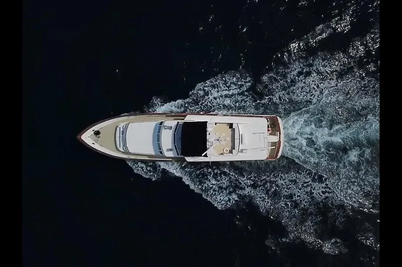 Sweet Freedom Yacht Photos Pics Aerial view of 1984 Broward CPMY Raised Pilothouse yacht cruising on dark water.