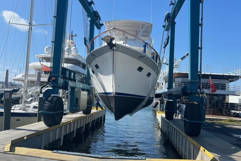 Bedouin Yacht Photos Pics DeFever 44 Sundeck Trawler 1998 being lifted at a marina with blue sky.