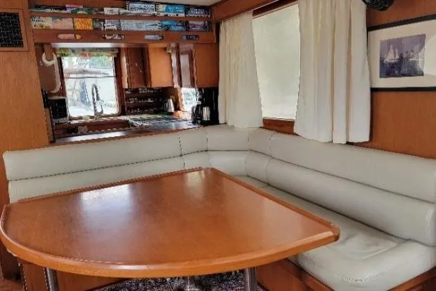 Bedouin Yacht Photos Pics Interior of 1998 DeFever 44 Sundeck Trawler with cozy dining area and wooden table.