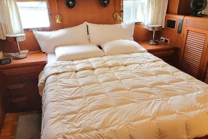 Bedouin Yacht Photos Pics Cozy bedroom in 1998 DeFever 44 Sundeck Trawler with plush bedding and wooden accents.