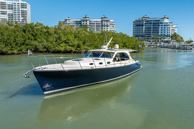 Miller Time Yacht Photos Pics 2017 Palm Beach Motor Yachts PB45 cruising in a scenic waterway with modern buildings.