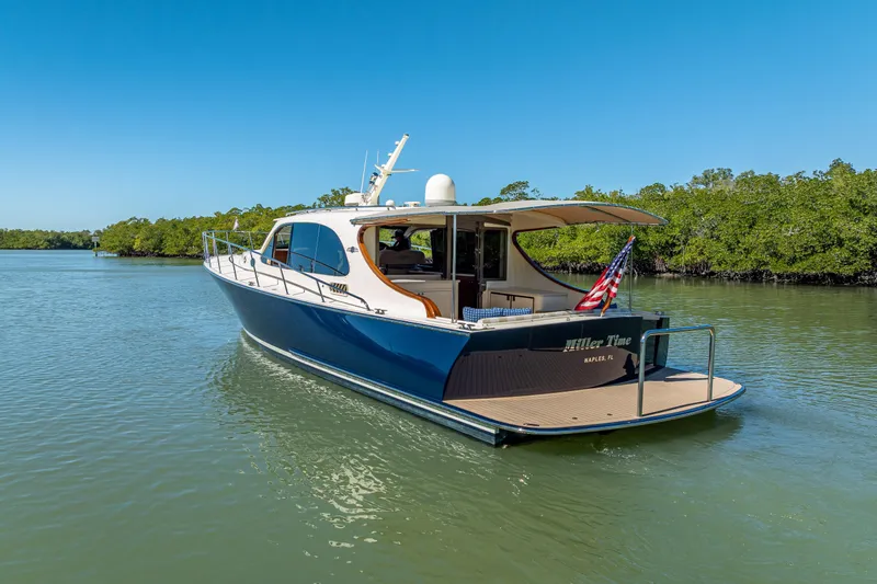 Miller Time Yacht Photos Pics 2017 Palm Beach Motor Yachts PB45 cruising on a serene waterway under clear blue skies.