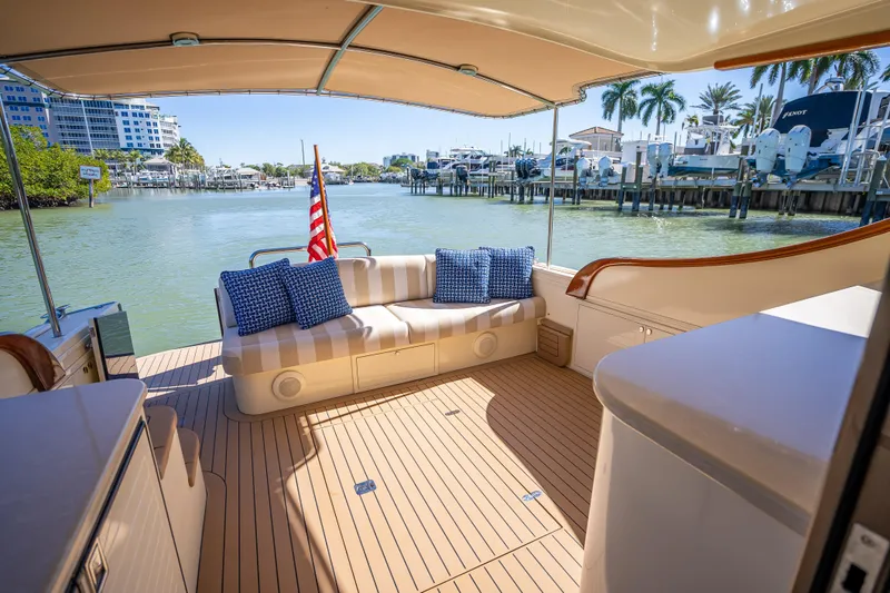 Miller Time Yacht Photos Pics 2017 Palm Beach Motor Yachts PB45 interior with seating, dock view, and American flag.