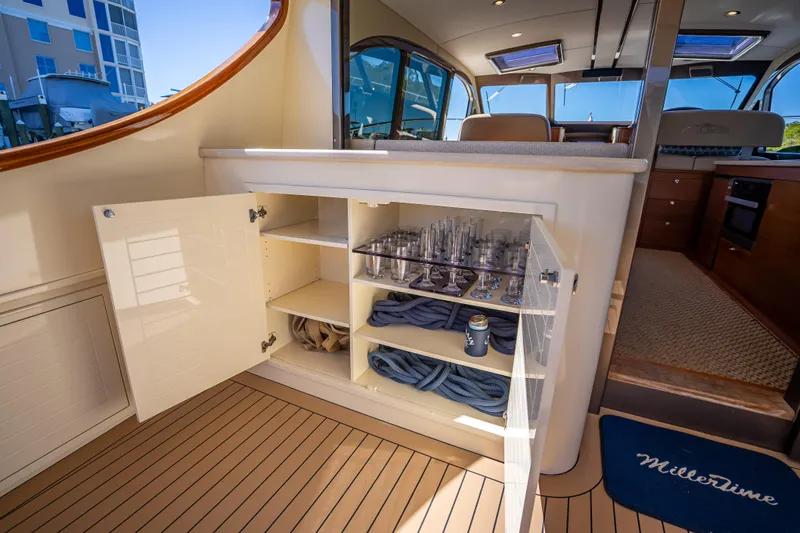 Miller Time Yacht Photos Pics 2017 Palm Beach Motor Yachts PB45 interior with open cabinet, glassware, and ropes.