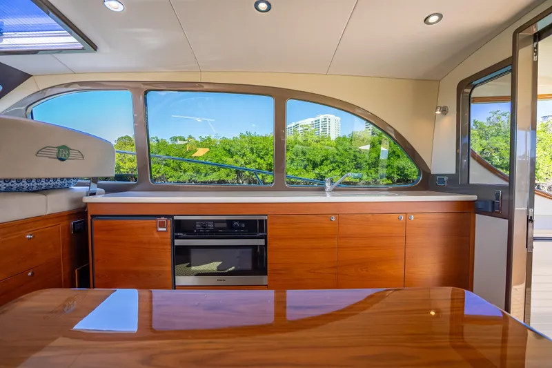 Miller Time Yacht Photos Pics Luxurious interior of 2017 Palm Beach Motor Yachts PB45 with sleek wood cabinetry and large windows.