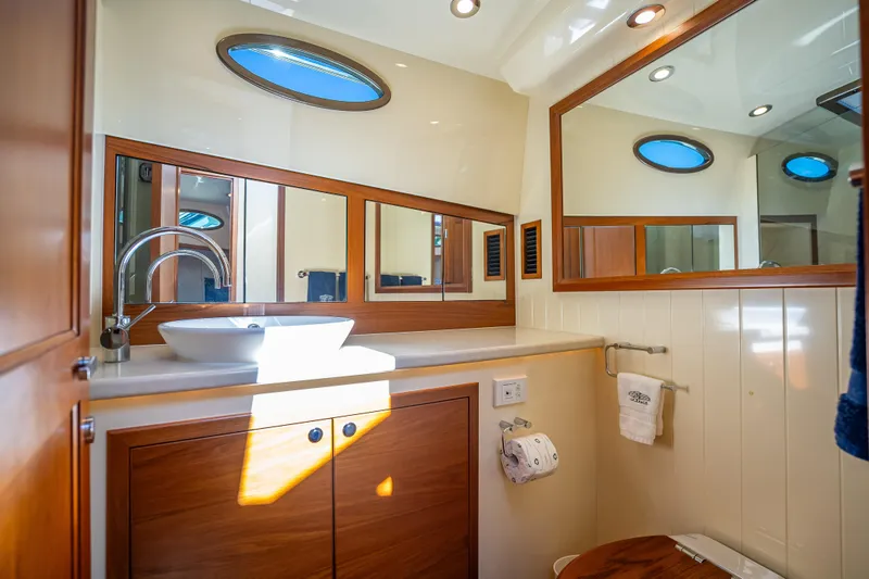 Miller Time Yacht Photos Pics Luxurious bathroom in 2017 Palm Beach Motor Yachts PB45, featuring elegant wood cabinetry and modern fixtures.